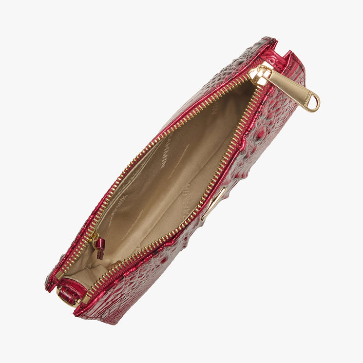 Brahmin red textured leather clutch with gold zipper, open to show beige interior lining. Top view displays structured silhouette and elegant hardware. Clutch is placed on a white background.