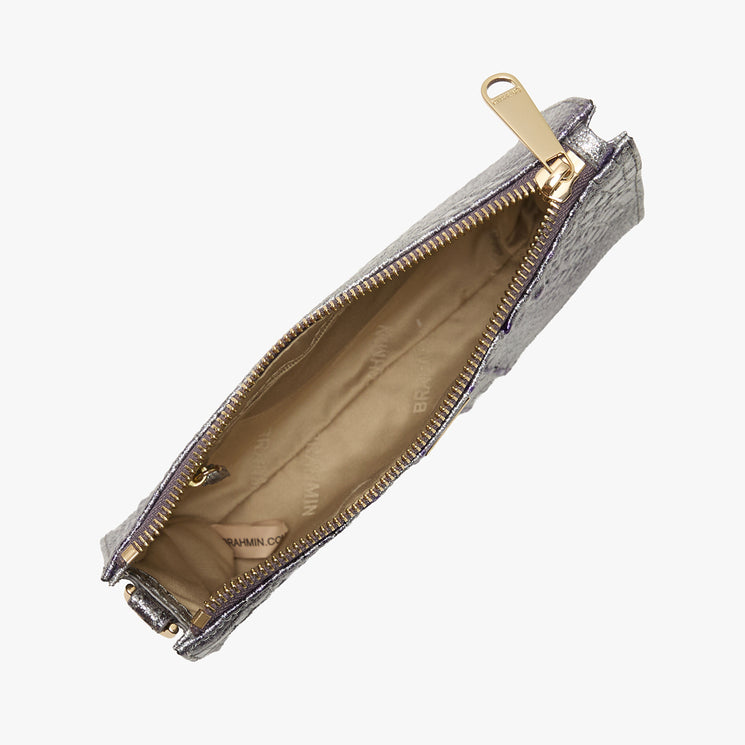 Open Brahmin clutch bag in metallic textured finish, top view, with gold zipper, beige fabric-lined interior, and small inner pocket; Brahmin brand name faintly visible inside.
