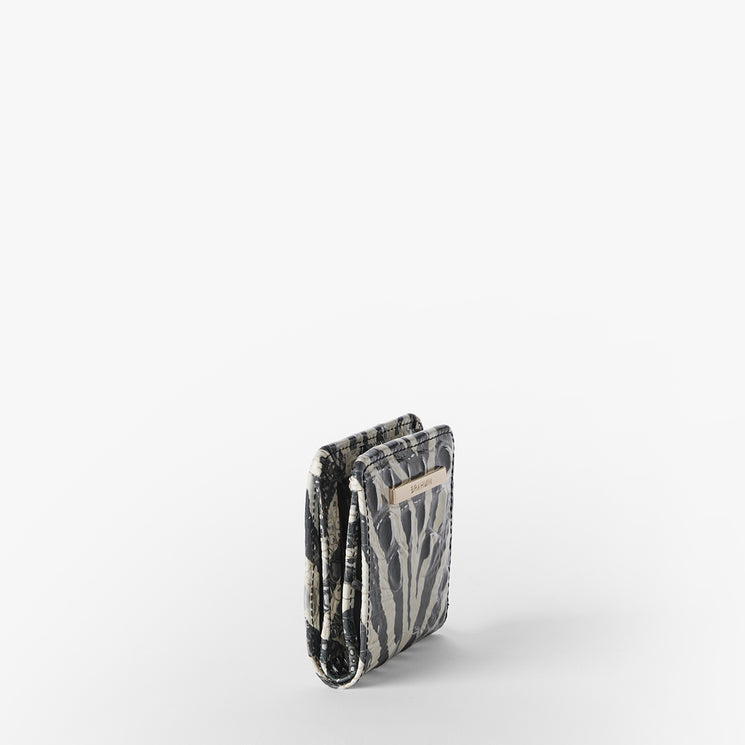 Brahmin small square wallet in black and white patterned design with metallic front logo plate, shown closed on a white background. The structured silhouette casts a faint shadow. No straps or interior details visible.
