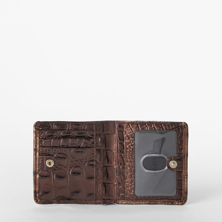 Brahmin brown embossed wallet displayed open, featuring card slots, a transparent ID window, snap button closures, and signature textured pattern against a white background.