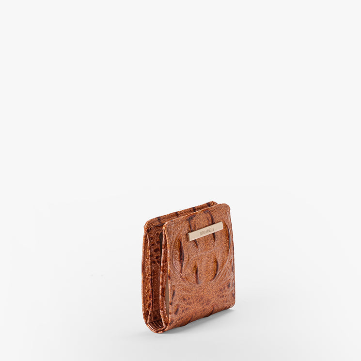 Brahmin small brown wallet with a textured leather finish and gold-tone metal label on the front, standing upright against a white background. Compact silhouette; exterior only is visible in this product image.