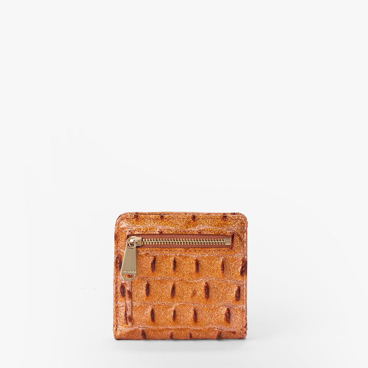 Brahmin small orange wallet with textured raised dot pattern, gold-tone front zipper pocket, compact rectangular silhouette; shown on a plain white background. No strap or interior details visible.