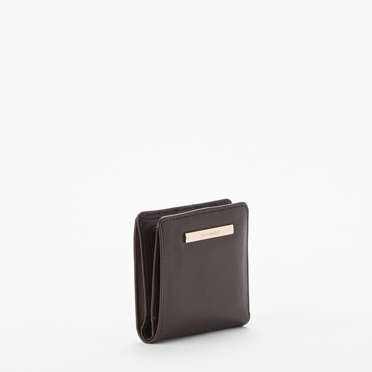 A dark brown leather bi-fold wallet with a small gold-tone metal brand plaque on the front, shown on a clean white background.