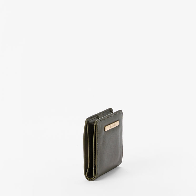 A slim, dark olive green leather wallet standing upright on a clean white background, featuring a small gold-tone metal plaque on the front.