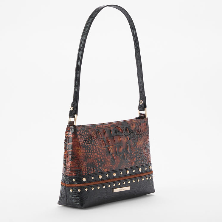 A shoulder handbag with a brown and black crocodile-embossed pattern, featuring a black strap, studded trim, and a small gold-tone plaque on a light gray background.