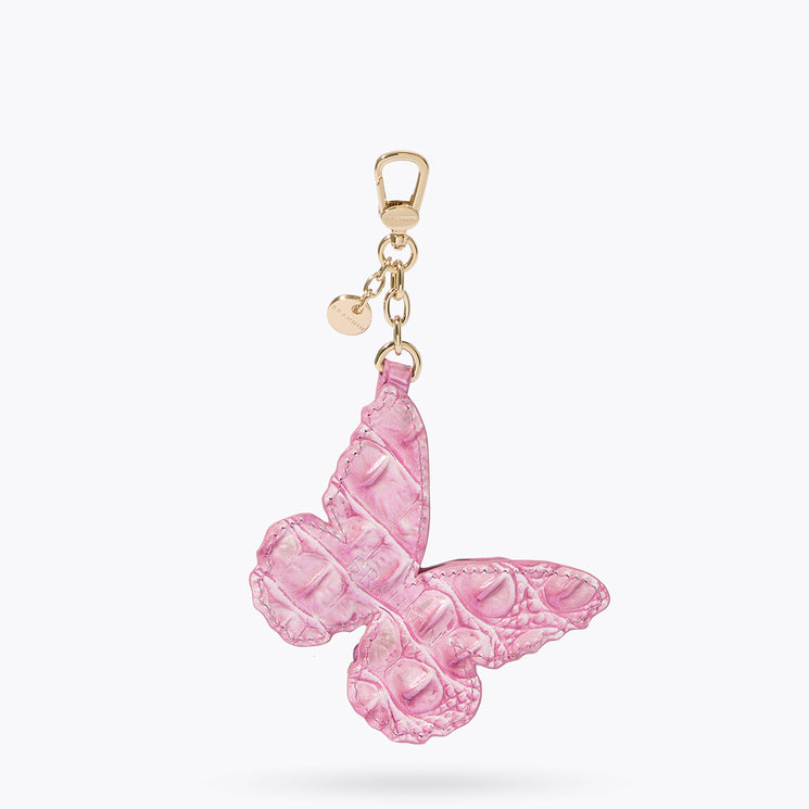 Brahmin pink butterfly-shaped keychain with textured finish, gold-tone clasp, and small round gold charm on chain, displayed against a white background.
