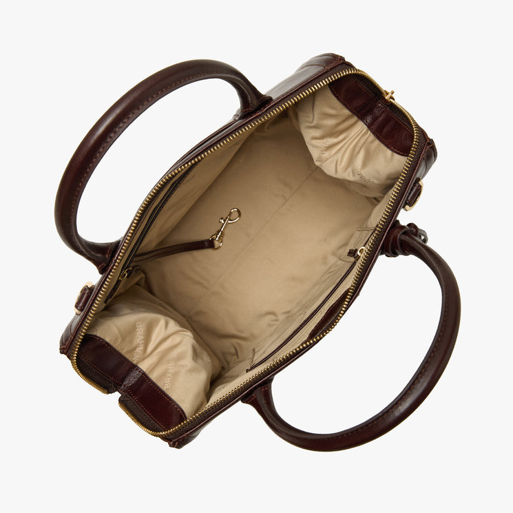 Brahmin brown handbag, open top view, shows beige interior with pockets, key leash clip, and zipper closure. Features two sturdy handles and textured finish. Satchel silhouette photographed empty from above.