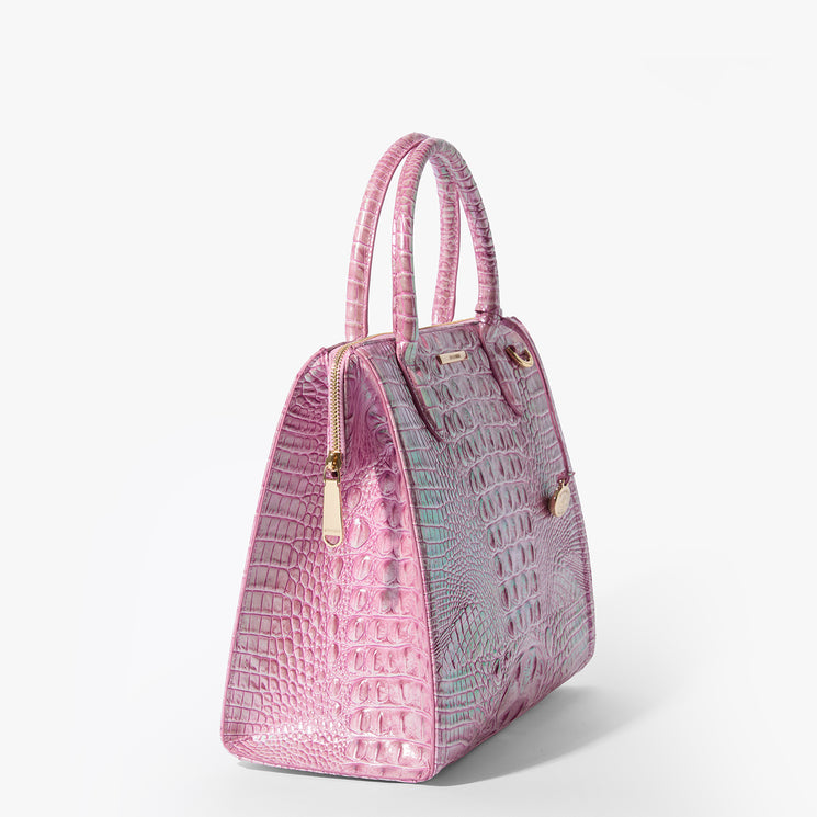 Brahmin pink handbag with embossed texture, gold hardware, dual top handles, and a structured silhouette, shown on a white background. No strap or interior details are visible in this front view.