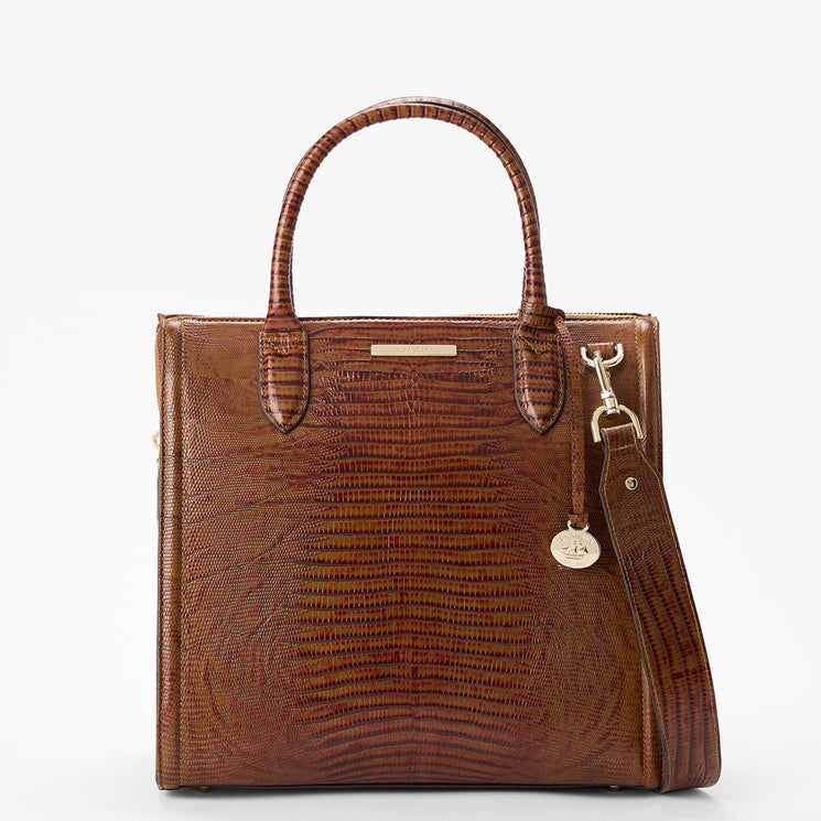 Brahmin brown structured satchel with an embossed textured pattern, two top handles, detachable shoulder strap, and small round gold-tone charm. Photographed from the front on a white background.