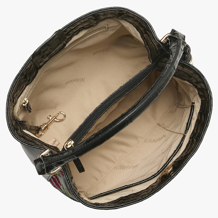 Top view of Brahmin black handbag with beige interior, multiple pockets, zippered center compartment, key clip, BRAHMIN logo on lining; structured silhouette, light gold-tone hardware visible.