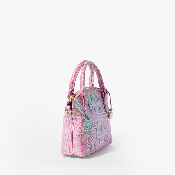 Brahmin handbag in pink and purple with embossed texture, gold-tone hardware, double top handles, and a structured silhouette, displayed on a white background. No strap or interior details visible.