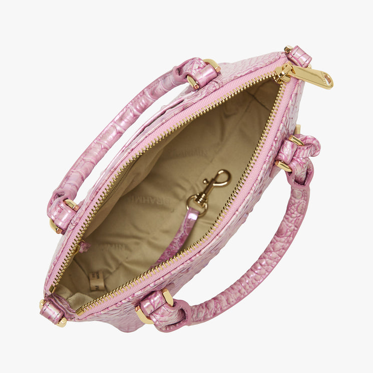 Top view of open Brahmin handbag in pink textured finish. Features gold zipper, hardware, two handles, attached strap hook inside, beige interior lining, and structured silhouette. Strap style is handheld or crossbody.