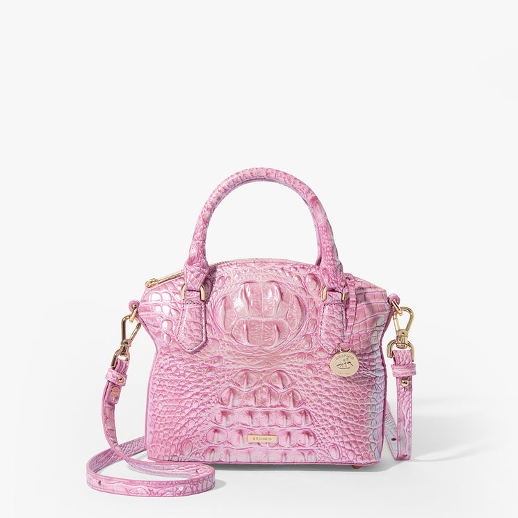 Brahmin Brooke Satchel in pink embossed texture with gold hardware, dual top handles, detachable shoulder strap, round gold Brahmin charm; shown on white background with structured silhouette and elegant design.