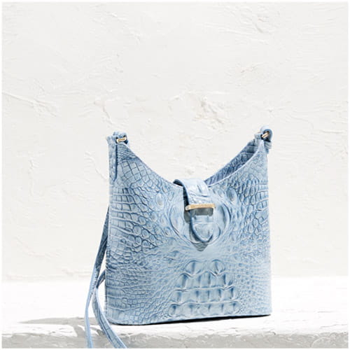 Light blue crocodile-embossed leather shoulder bag with adjustable strap, displayed on a neutral background.