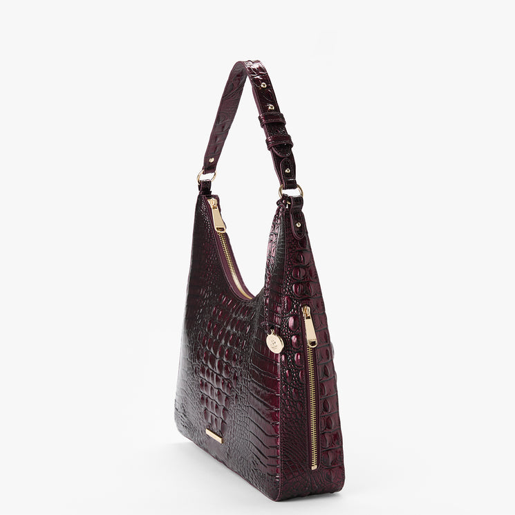 A dark burgundy crocodile-embossed shoulder bag with gold-tone hardware, shown from a three-quarter angle against a light gray background.