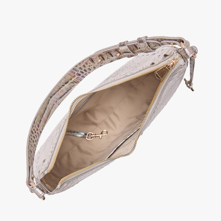 Top view of an open Brahmin beige handbag with embossed texture, gold zipper hardware, and beige lining. Interior shows a hook and pockets. Features a single adjustable shoulder strap and structured silhouette.