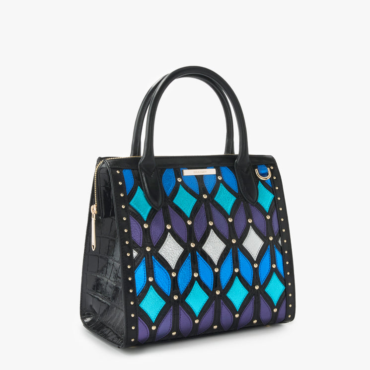 BRAHMIN Small Caroline satchel with two top handles, detachable crossbody strap, blue-purple-silver geometric diamond print exterior, gold-tone studs, structured silhouette, and branded hardware.