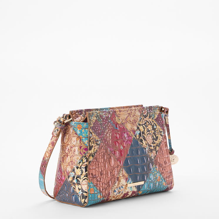 Brahmin patchwork shoulder bag featuring embossed texture, vibrant multicolor panels, gold-tone hardware, and a long strap; shown on a plain white background with bag silhouette and exterior details visible.