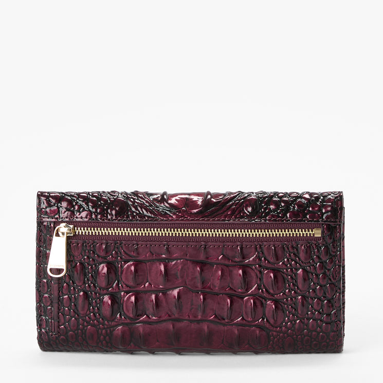 A metallic burgundy crocodile-embossed leather wallet with a gold zipper, shown against a plain white background.