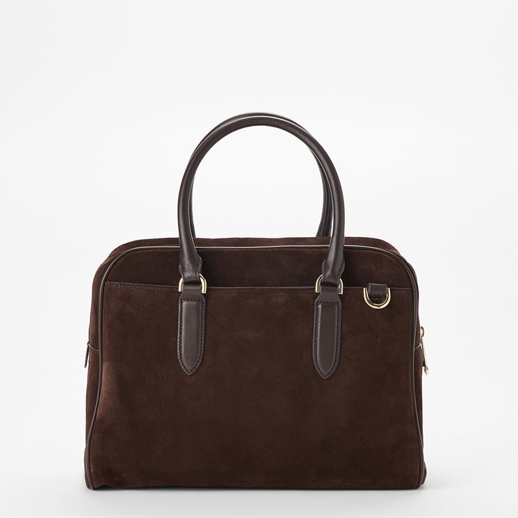 A dark brown suede satchel handbag with dark brown leather handles and trim, featuring gold-tone hardware, photographed against a seamless white background.