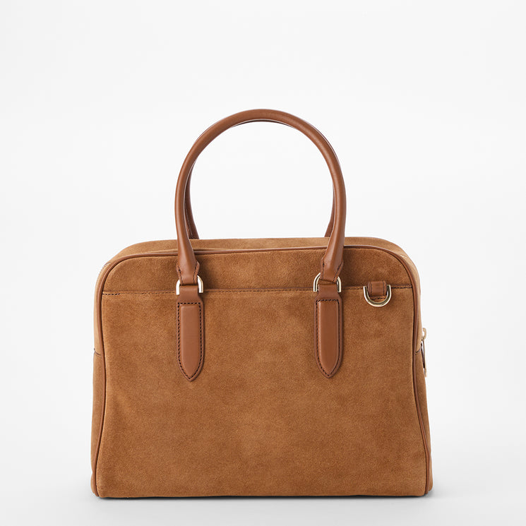 A structured brown suede handbag with dual top handles, gold-tone hardware, and a zip-around closure, photographed against a clean white background.