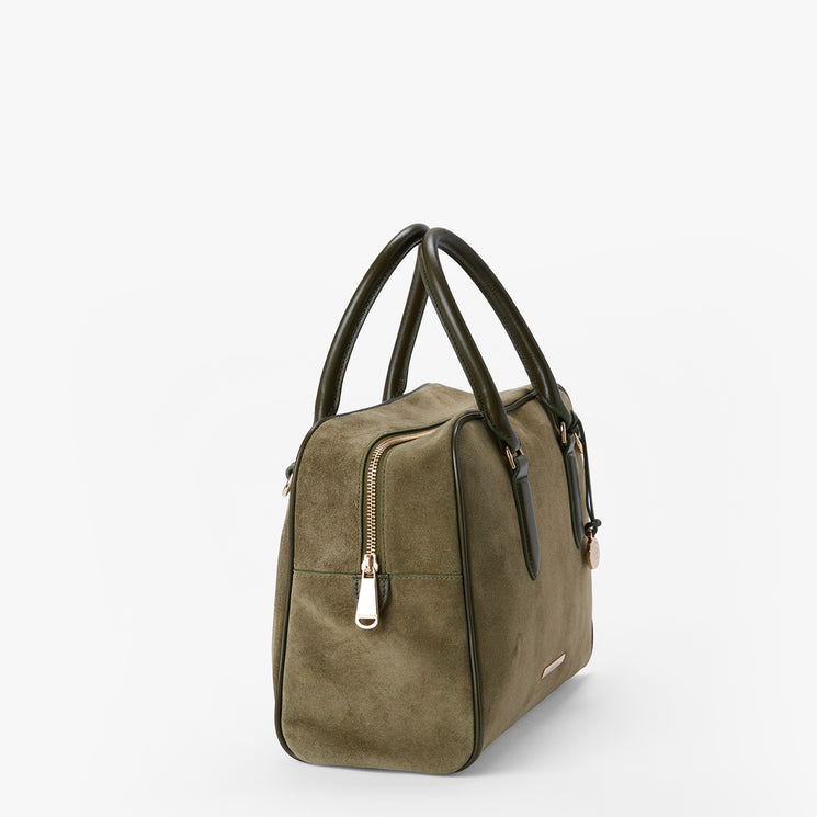 An olive green suede handbag with dark green leather handles and gold-tone hardware, shown from a three-quarter angle on a light gray background.