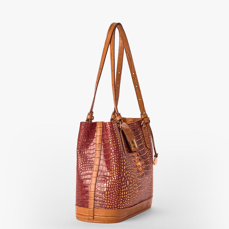 A structured tote bag featuring a reddish-brown crocodile-embossed texture on the main body and smooth tan leather trim, handles, and base, shown against a plain light gray background.