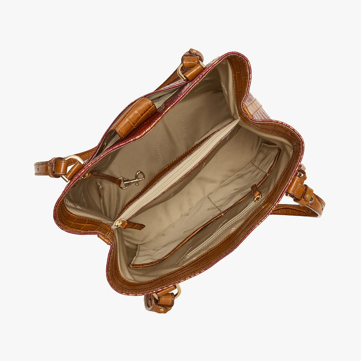 An overhead view of an open brown leather handbag showing its beige interior lining, zippered compartments, and gold-tone hardware, set against a plain white background.