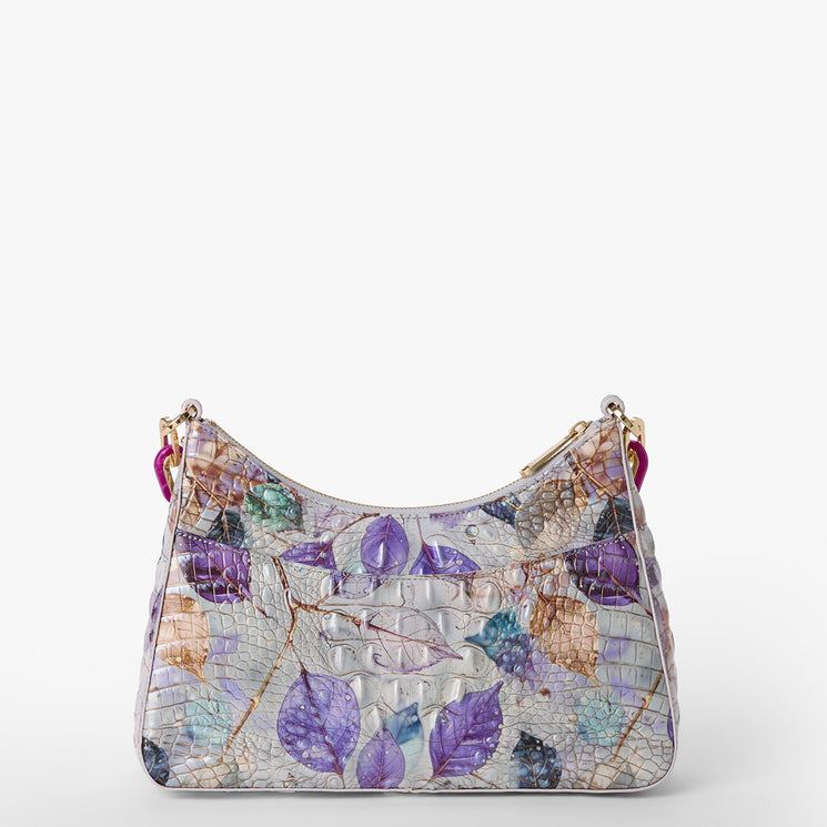 Brahmin small handbag with textured multicolored surface, purple, blue, and beige leaf pattern, structured rectangular silhouette, gold hardware, top handle strap; shown against a plain white background.