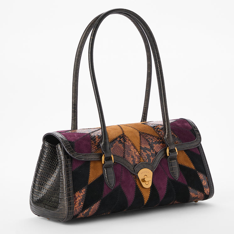A structured handbag with a geometric patchwork pattern in purple, brown, and black, featuring textured black leather handles and trim with a gold-tone turn-lock closure.