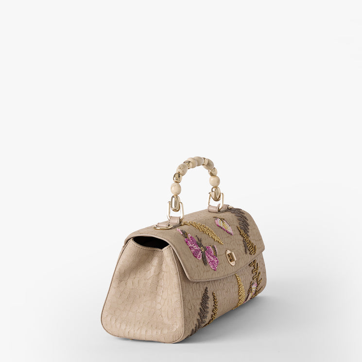 Beige handbag with butterfly and fern embroidery on a white background. Dayan side view.