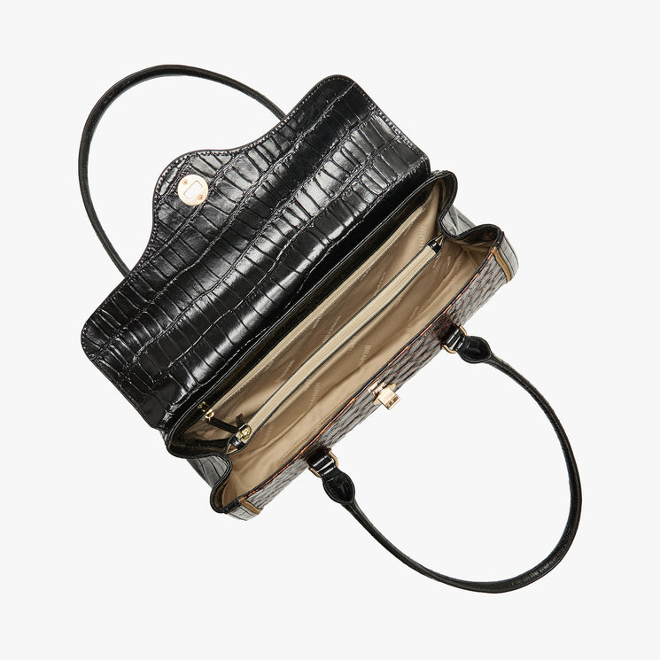 Black crocodile-embossed leather handbag shown open from a top-down view, revealing a beige interior lining and gold-tone hardware, on a light gray background.