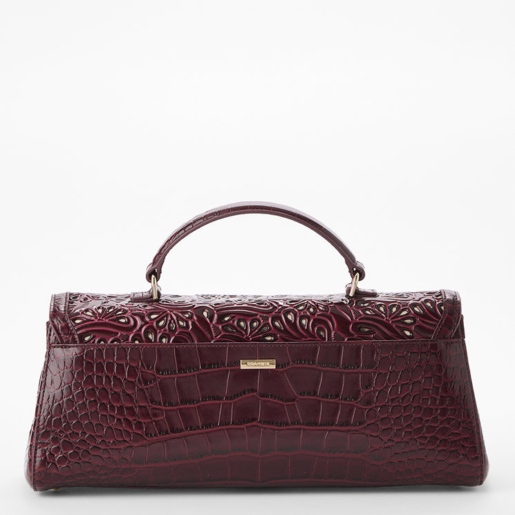 A burgundy embossed leather handbag with a crocodile-embossed lower body, a top handle, and a small gold-tone logo plate, shown against a plain white background.
