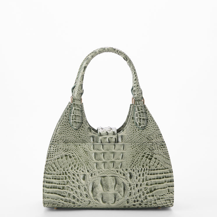 A structured shoulder bag with a crocodile skin texture in a muted sage green color, featuring dual top handles and a silver-tone metal clasp closure at the top center, set against a plain white background.