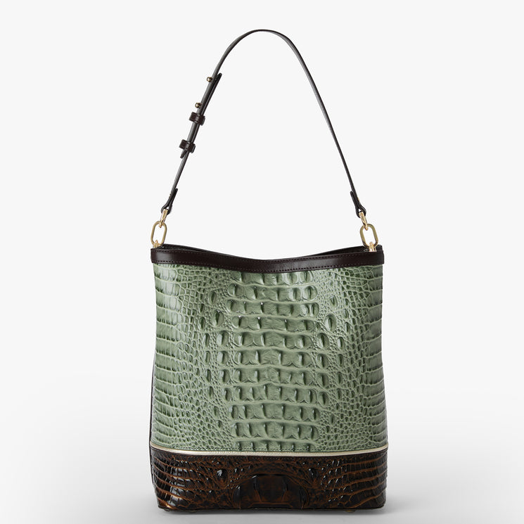 A structured shoulder bag featuring a light sage green crocodile-embossed leather body, dark brown leather trim at the top and bottom, and a thin shoulder strap with gold-tone hardware, shown against a plain white background.