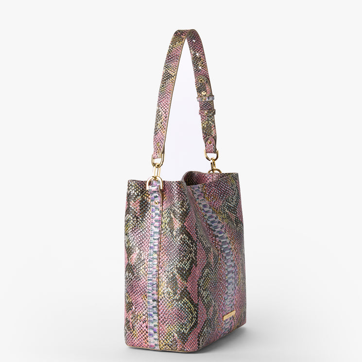 Brahmin bucket handbag in pink, purple, and green textured pattern with gold hardware, adjustable shoulder strap, and a structured silhouette. Shown against a white background. Strap designed for shoulder carry.