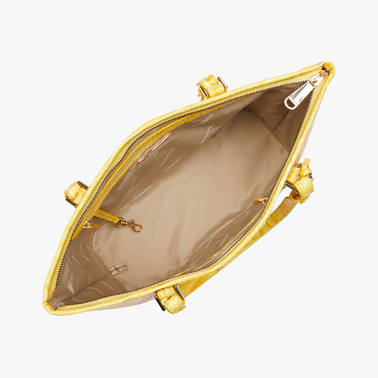 Top view of open Brahmin handbag in yellow with structured shape, beige interior lining, gold-tone hardware, zippered side pocket, key clasp, and large main compartment. Silhouette designed for shoulder or arm carry.