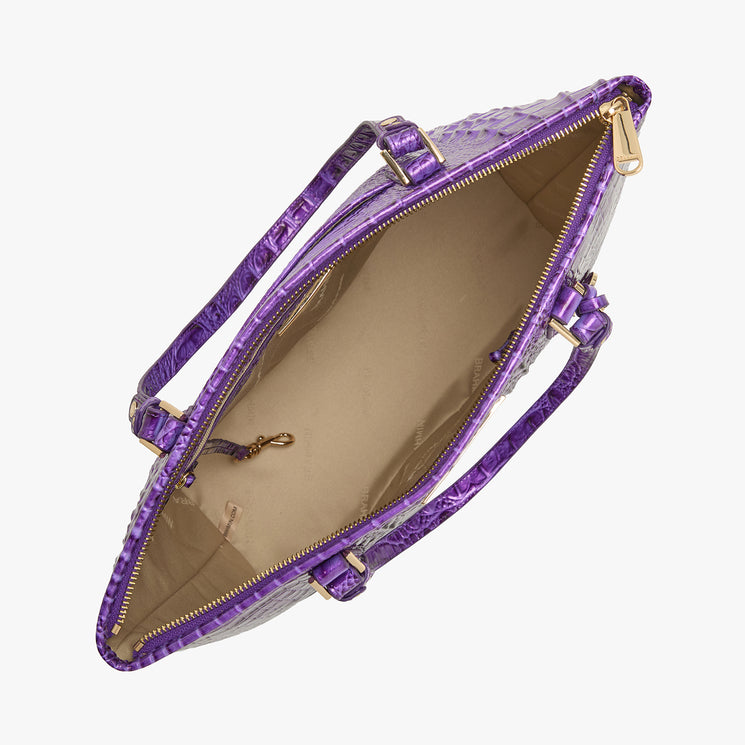 Brahmin purple embossed handbag, top view, open with beige interior lining, gold-tone zipper closure, dual handles, structured silhouette, multiple inner pockets visible for organization.