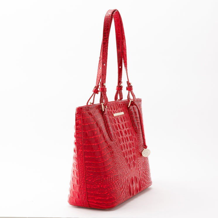 Bright red Brahmin Medium Asher tote in a structured silhouette with dual shoulder straps and a glossy embossed texture, shown from a side angle.