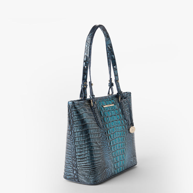 Brahmin Medium Asher tote with textured embossed pattern, double top handles, gold-tone hardware, and a round gold charm, shown against a plain white background.