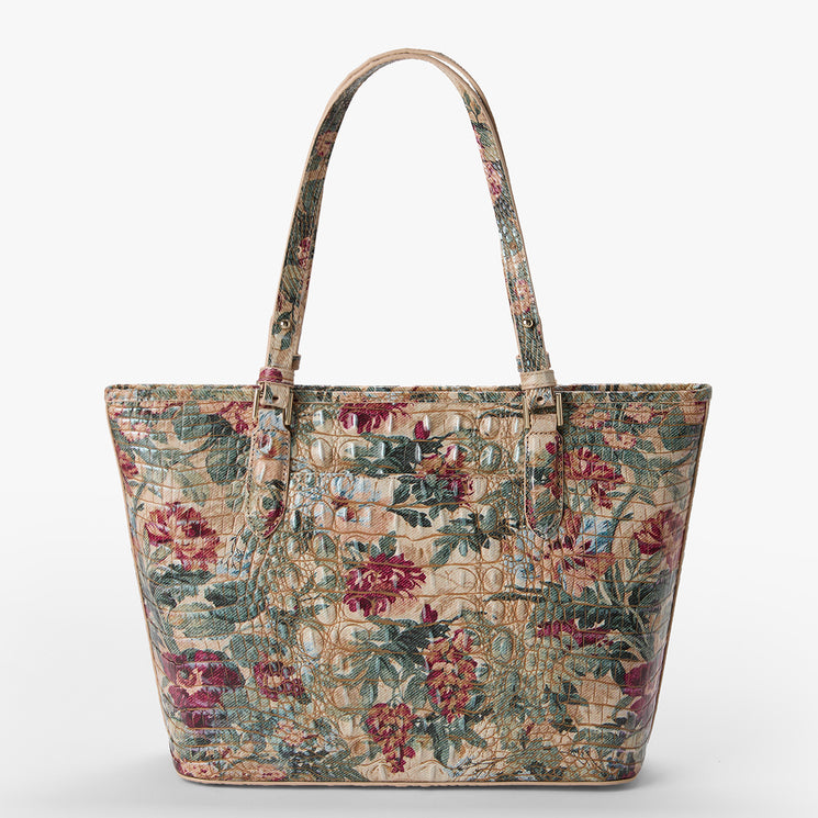 A structured tote bag featuring a crocodile-embossed texture with a vintage floral print in muted red, green, and beige tones, set against a plain light gray background.