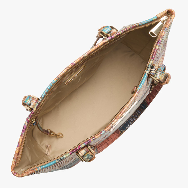 Top view of an open Brahmin multicolored handbag featuring a beige interior with gold-tone hardware, multiple inner pockets, zippered closure, and spacious storage; structured silhouette with dual top handles visible.