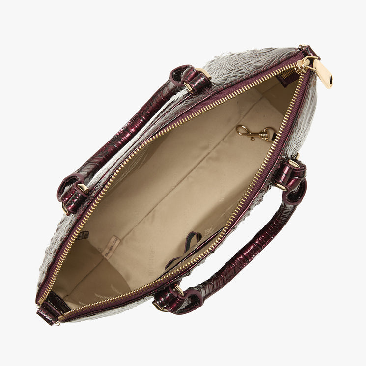 An open handbag with a textured red exterior, deep burgundy handles, and gold-tone hardware, shown against a plain white background.