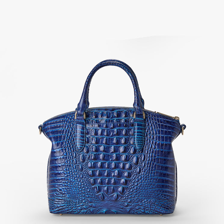 Brahmin structured blue satchel with embossed crocodile pattern, two top handles, gold-tone hardware, and a structured silhouette. The bag is displayed on a plain white background.