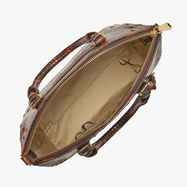 An open designer handbag with a brown and black textured crocodile-embossed exterior, gold-tone hardware, and a beige interior lining, shown on a light gray background.