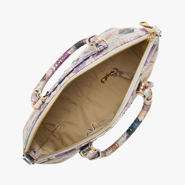 Top view of Brahmin satchel in multicolored textured pattern, featuring tan interior lining, two top handles, inner slip pockets, and gold-tone clasp. Bag is open and empty against a white background.