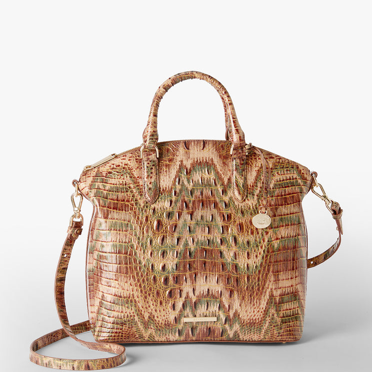 A structured handbag with a crocodile-embossed texture in earthy brown, beige, and muted green tones, featuring dual top handles and a gold Brahmin logo plaque. Large Duxbury Satchel Front View with Strap.