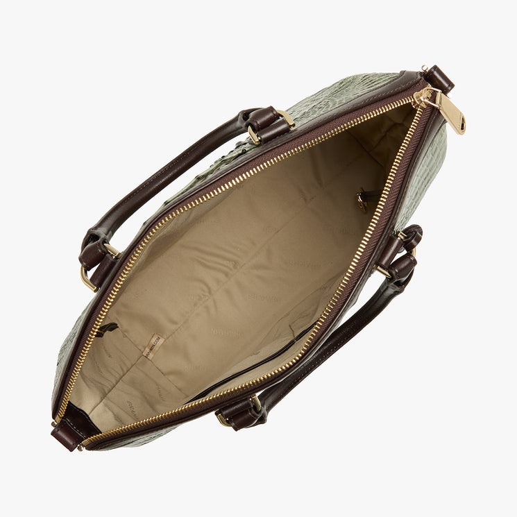 An overhead view of a handbag's open interior, showing a beige quilted lining, dark brown leather handles and trim, and gold-tone zipper hardware on a light gray background.