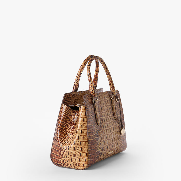 Brahmin brown embossed handbag with dual top handles, structured silhouette, gold-tone pendant hardware, and textured pattern. Bag is angled on a plain white background; interior not visible.