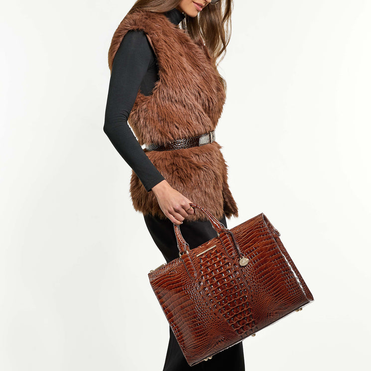 Woman wearing a brown fur vest and holding Business Tote in hand on a white background